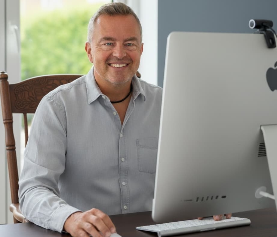 Rainer Schwenkkraus vor einem Monitor in einer Onlineberatung.